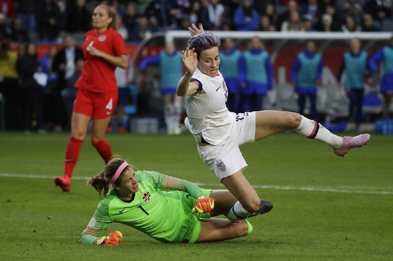 United States forward Megan Rapinoe (right) scores past Canada goalkeeper Stephanie Labre during the second half of the teams’ CONCACAF Women’s Olympic qualifying tournament final. The top-ranked U.S. women won 3-0 behind goals from Rapinoe, Lynn Williams and Lindsey Horan.