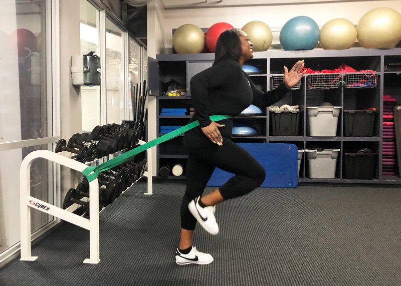 Mavis Pryor does the Stretch Band Running Man exercise in Little Rock Racquet Club's indoor tennis center fitness room. (Arkansas Democrat-Gazette/Celia Storey)