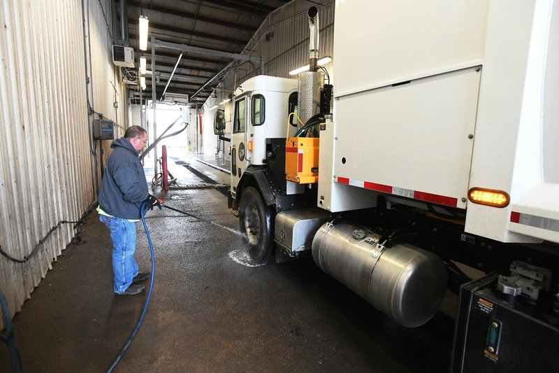 Route driver Veldean Littrell cleans a garbage truck Thursday at Fayetteville's fleet wash facility on Happy Hollow Road. The city plans to start construction of a $1.3 million fleet wash facility next month. (NWA Democrat-Gazette/J.T. Wampler)