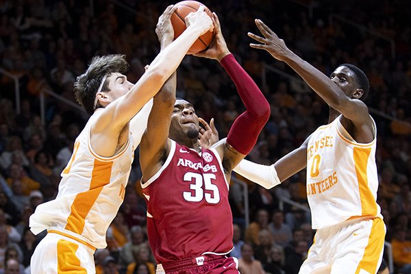 Arkansas forward Reggie Chaney (35) is defended by Tennessee forward John Fulkerson (10) and Tennessee guard Davonte Gaines (0) during an NCAA college basketball game, Tuesday, Feb. 11, 2020 in Knoxville, Tenn. (Brianna Paciorka/Knoxville News Sentinel via AP)


