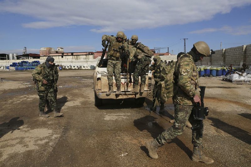 Turkish-backed fighters prepare to move to the front lines Monday in Syria’s Idlib province. More photos at arkansasonline.com/ 211syria/.  