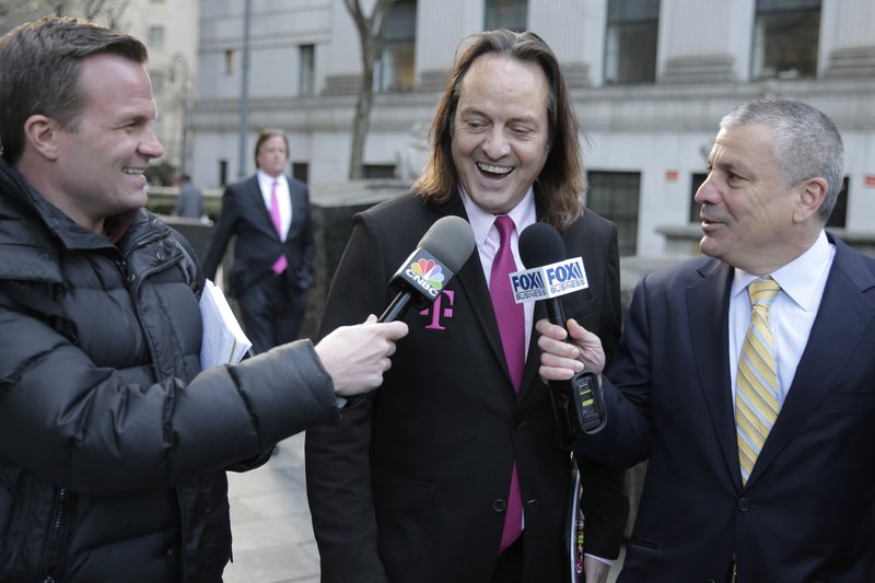 FILE - In this Jan. 15, 2020, file photo T-Mobile chief executive John Legere speaks to reporters as he leaves the courthouse in New York. A federal judge has removed a major obstacle to T-Mobile's $26.5 billion takeover of Sprint, as he rejected claims by a group of states that the deal would mean less competition and higher phone bills. (AP Photo/Seth Wenig, File)