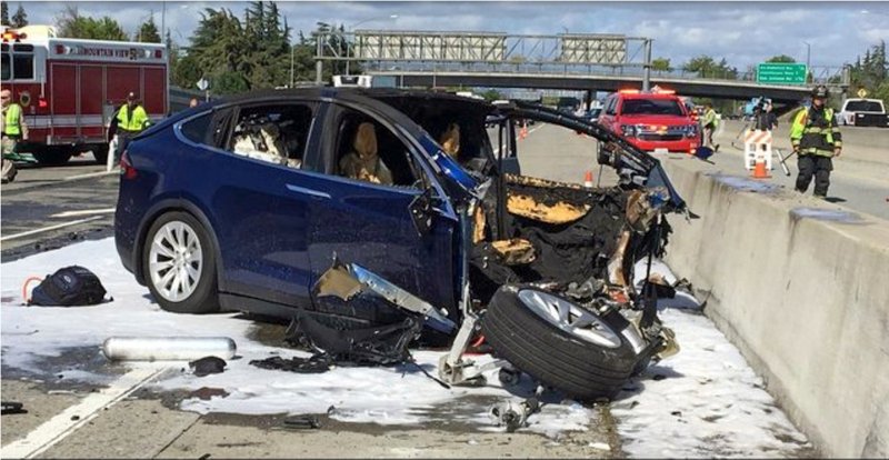 FILE - In this March 23, 2018, file photo provided by KTVU, emergency personnel work a the scene where a Tesla electric SUV crashed into a barrier on U.S. Highway 101 in Mountain View, Calif. The Apple engineer who died when his Tesla Model X crashed into the concrete barrier complained before his death that the SUV's Autopilot system would malfunction in the area where the crash happened. The complaints were detailed in a trove of documents released Tuesday, Feb. 11, 2020, by the U.S. National Transportation Safety Board, which is investigating the March, 2018 crash that killed engineer Walter Huang. (KTVU-TV via AP, File)