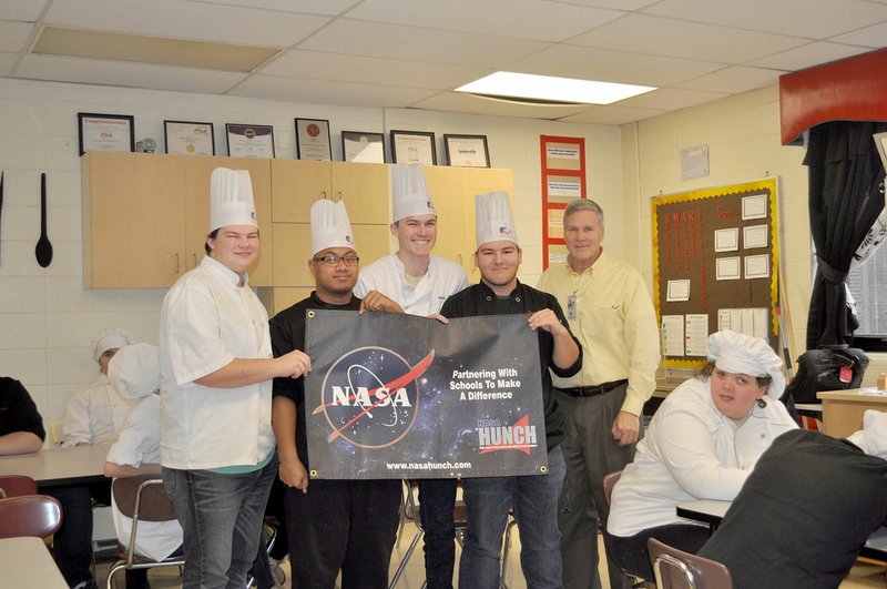 RACHEL DICKERSON/MCDONALD COUNTY PRESS Bob Zeek of NASA (right) presents a banner to McDonald County High School culinary students Zeke Boze (left), Omar Manuel, Wade Rickman and Dylan Gerow on Feb. 7.