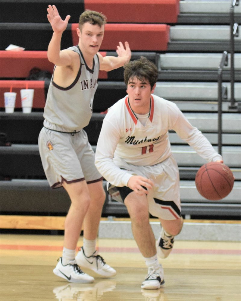 RICK PECK/SPECIAL TO MCDONALD COUNTY PRESS McDonald County's Cole Martin drives past Strafford's Vance Mullins during the Mustangs' 66-47 loss on Feb. 4 at MCHS.