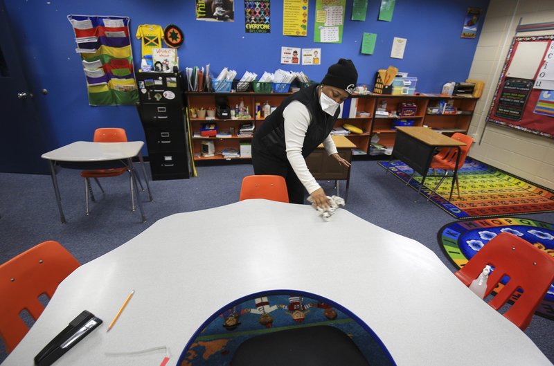 In this file photo Principal Shoutell Richardson helps disinfect a classroom at Rockefeller Elementary and Early Childhood Center in Little Rock. At least 36 Arkansas schools or school districts have closed briefly because of the flu.
(Arkansas Democrat-Gazette/Staton Breidenthal)