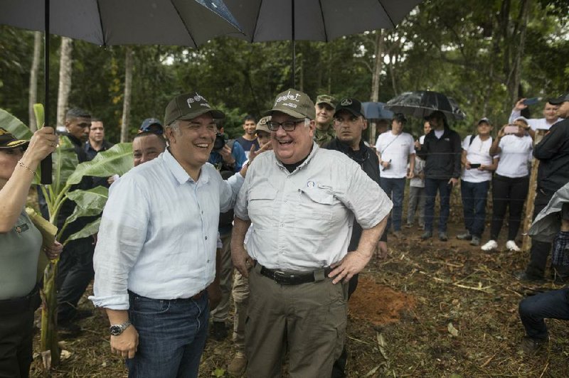 Colombian President Ivan Duque (left) and American philanthropist Howard Buffett tour a cocoa farm in La Gabarra, Colombia, in late January.
(AP/Ivan Valencia)