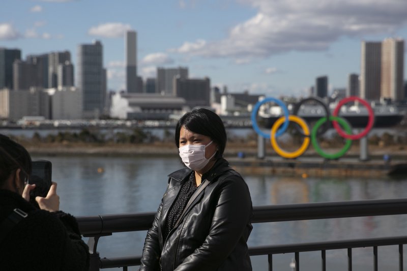 The Associated Press TAKING PRECAUTIONS: On Jan. 29, a tourist wearing a mask poses for a photo with the Olympic rings in the background at Tokyo's Odaiba district. Tokyo Olympic organizers repeated their message at the start of two days of meetings with the IOC: this summer's games will not be cancelled or postponed by the coronavirus spreading neighboring China. story.lead_photo.caption