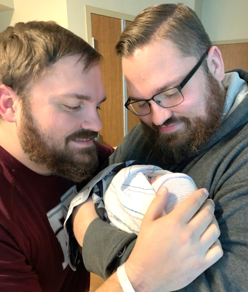 El Dorado News-Times managing editor Caleb Slinkard holds his nephew, also named Caleb Slinkard, along with his brother, Joshua Slinkard.