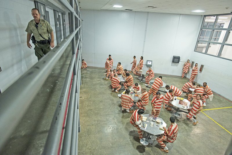 Inmates spend time in dayroom in 2014 at the Washington County Detention Center in Fayetteville. Overcrowding in pods forces some inmates to sleep on extra mats on the floor. (File photo/NWA Democrat-Gazette/Anthony Reyes)