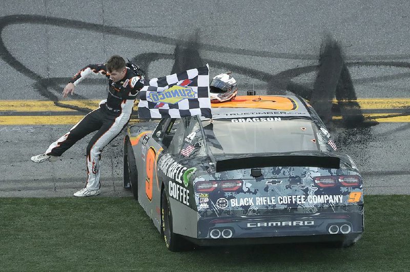 Driver Noah Gragson slides across the hood of his car while celebrating his victory in Saturday’s NASCAR Xfi nity Series race at Daytona International Speedway.
(AP/Chris O’Meara)