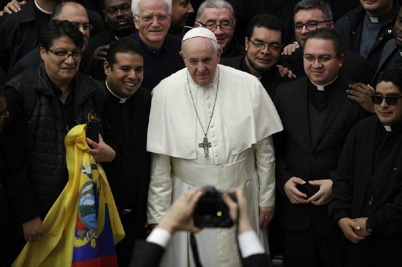 Priests pose for a photo with Pope Francis during his weekly general audience at the Vatican on Wednesday.
(AP/Gregorio Borgia)