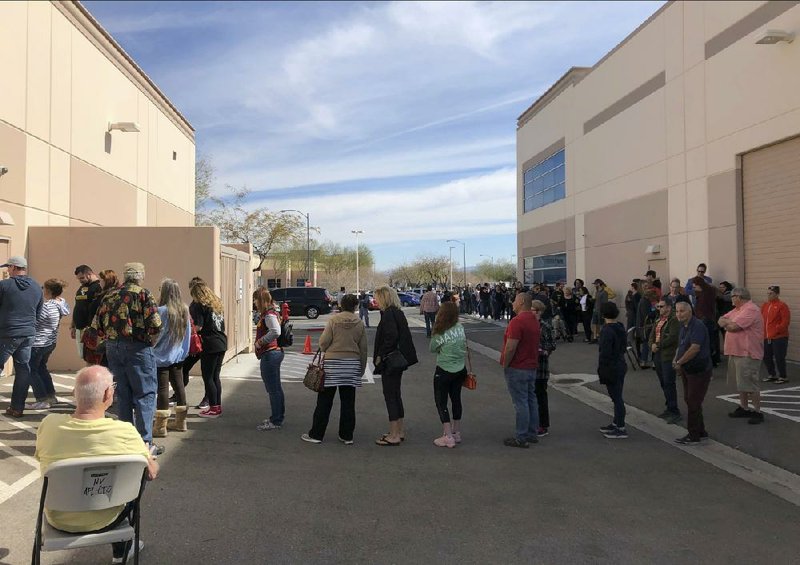 Democratic caucus-goers wait in line for more than an hour Saturday in an early caucus ballot precinct site at an AFL-CIO union office in Henderson, Nev. More photos at arkansasonline.com/216nevada/.
(AP/Ken Ritter)