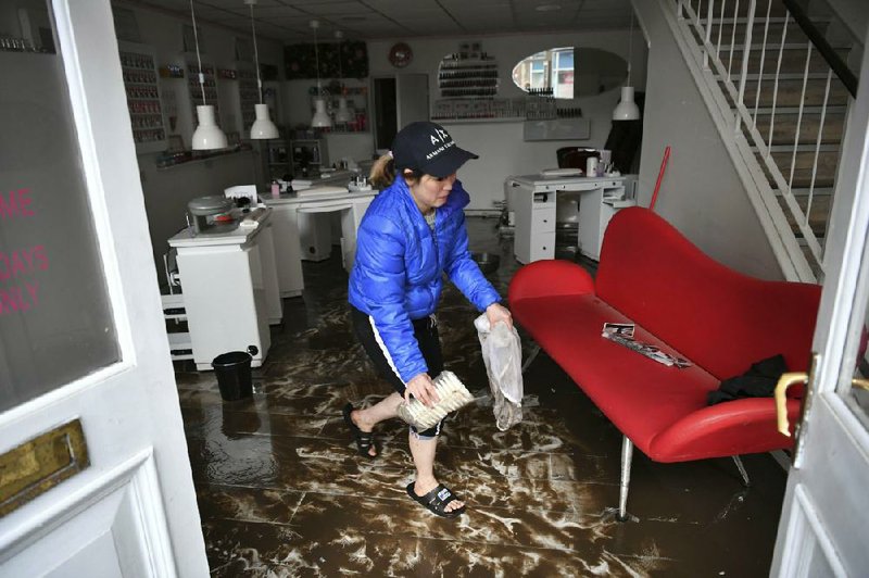 An employee cleans up in a nail salon Sunday after Storm Dennis resulted in widespread flooding in Pontypridd, Wales. More photos at arkansasonline.com/217dennis/.
(AP/Ben Birchall)