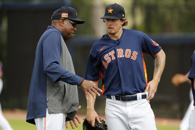 Houston Astros manager Dusty Baker, left, talks with pitcher Chris Devenski during spring training practice Thursday in West Palm Beach, Fla. - Photo by Jeff Roberson of The Associated Press