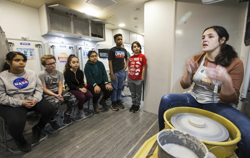 Angela Korbe teaches fifth-graders how to throw pottery Tuesday in the Wheel Mobile Traveling Art Studio during a stop at Tucker Elementary School in Rogers. Go to nwaonline.com/photos to see more photos. (NWA Democrat-Gazette/Ben Goff)