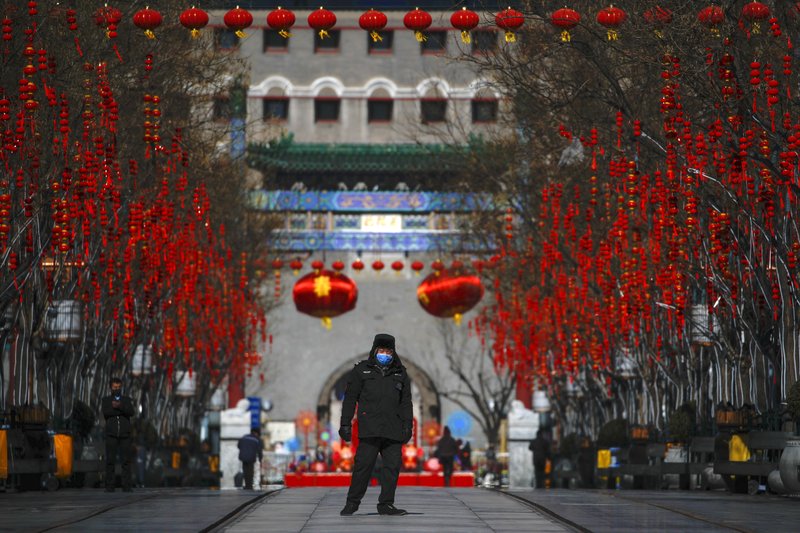 A security guard in Beijing wears a face mask Sunday as he walks on deserted Qianmen Street, usually a popular tourist spot. China’s National Health Commission today reported a slight increase in the number of new coronavirus cases on the mainland after reporting decreases the previous three days. More photos at arkansasonline.com/217virus.
(AP/Andy Wong)