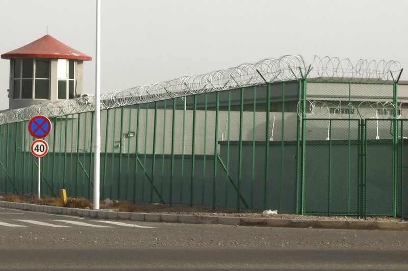 FILE - In this Dec. 3, 2018, file photo, a guard tower and barbed wire fences surround an internment facility in the Kunshan Industrial Park which has previously been revealed by leaked documents to be a forced indoctrination camp in Artux in western China's Xinjiang region. A database obtained by The Associated Press offers the fullest and most personal view yet into how Chinese officials decided who to put into and let out of detention camps, as part of a massive crackdown that has locked away more than a million ethnic minorities, most of them Muslim. (AP Photo/Ng Han Guan, File)