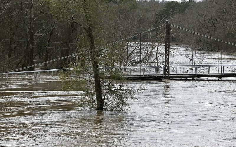 Water from the Pearl River on Monday inundates a bridge connecting Hinds and Rankin counties in Byram, Miss. More photos at arkansasonline.com/218flooding/.
(AP/Rogelio V. Solis)