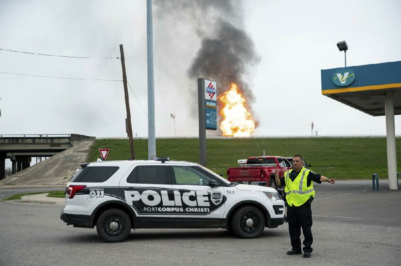 A police officer directs traffic Monday off Interstate 37 in Corpus Christi, Texas, after a fire began in a pipeline at the nearby Citgo refinery.
(AP/Corpus Christi Caller-Times/Courtney Sacco)