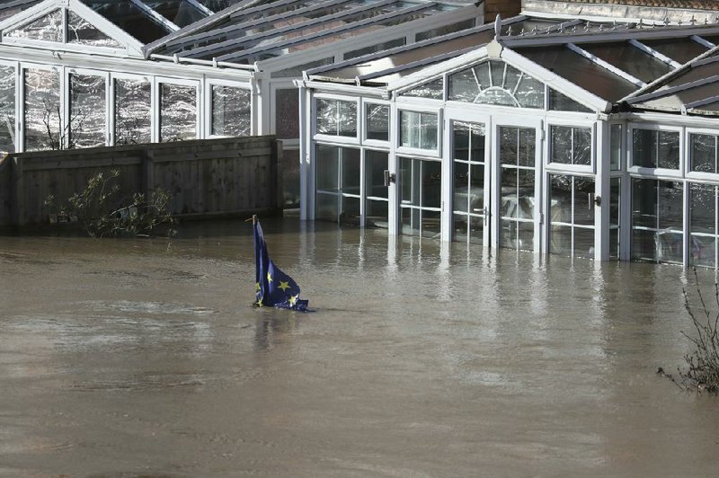 A European Union flag is nearly covered by water Monday in Hereford, England, in the aftermath of Storm Dennis. More photos at arkansasonline.com/218uk/.
(AP/PA/Steve Parsons)