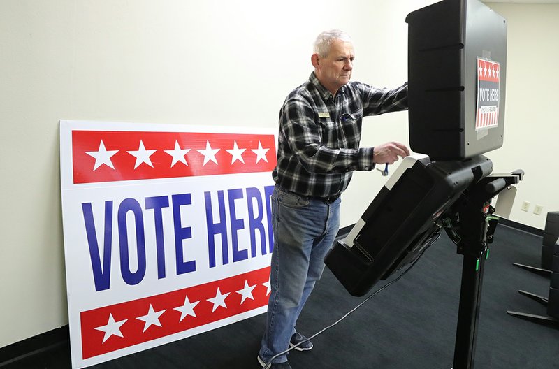 In this file photo Garland County Election Commission Chairman Gene Haley sets up a voting machine at the Hot Springs Mall in preparation for the start of early voting. - Photo by Richard Rasmussen of The Sentinel-Record