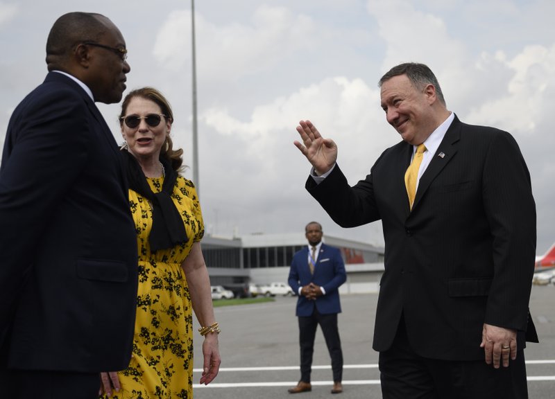 US Secretary of State, Mike Pompeo, right, and his wife, Susan Pompeo, center, greets Angola Foreign Minister, Manuel Domingos Augusto on the tarmac before leaving Angola at the Luanda International Airport in Luanda, Angola, Monday Feb. 17, 2020. Pompeo started his tour of Africa in Senegal, the first U.S. Cabinet official to visit in more than 18 months. He left Senegal Sunday to arrive in Angola and will then travel on to Ethiopia as the Trump administration tries to counter the growing interest of China, Russia and other global powers in Africa and its booming young population of more than 1.2 billion. (Andrew Caballero-Reynolds/Pool via AP)