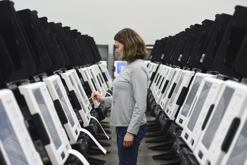 Julie Hall, staff assistant, tests a ballot marking machine, Thursday, January 23, 2020 at the Benton County Clerk's Office in Rogers.