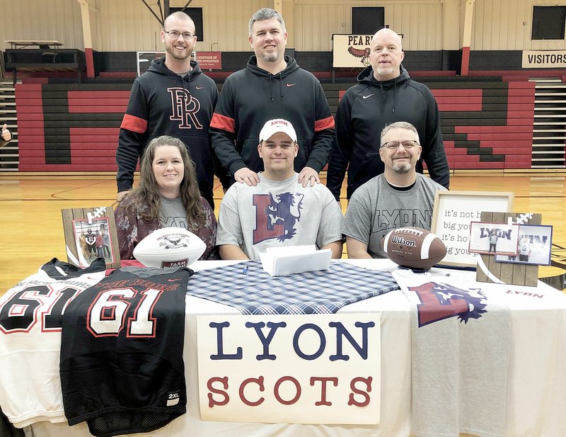 TIMES photograph by Annette Beard Blackhawk Phillip Brown was joined by parents Shannon and Lindsey Brown Jr. and coaches Cody Alexander, Asa Poteete and Stephen Neal in celebration of his signing to play football for Lyon College on Wednesday, Feb. 5.