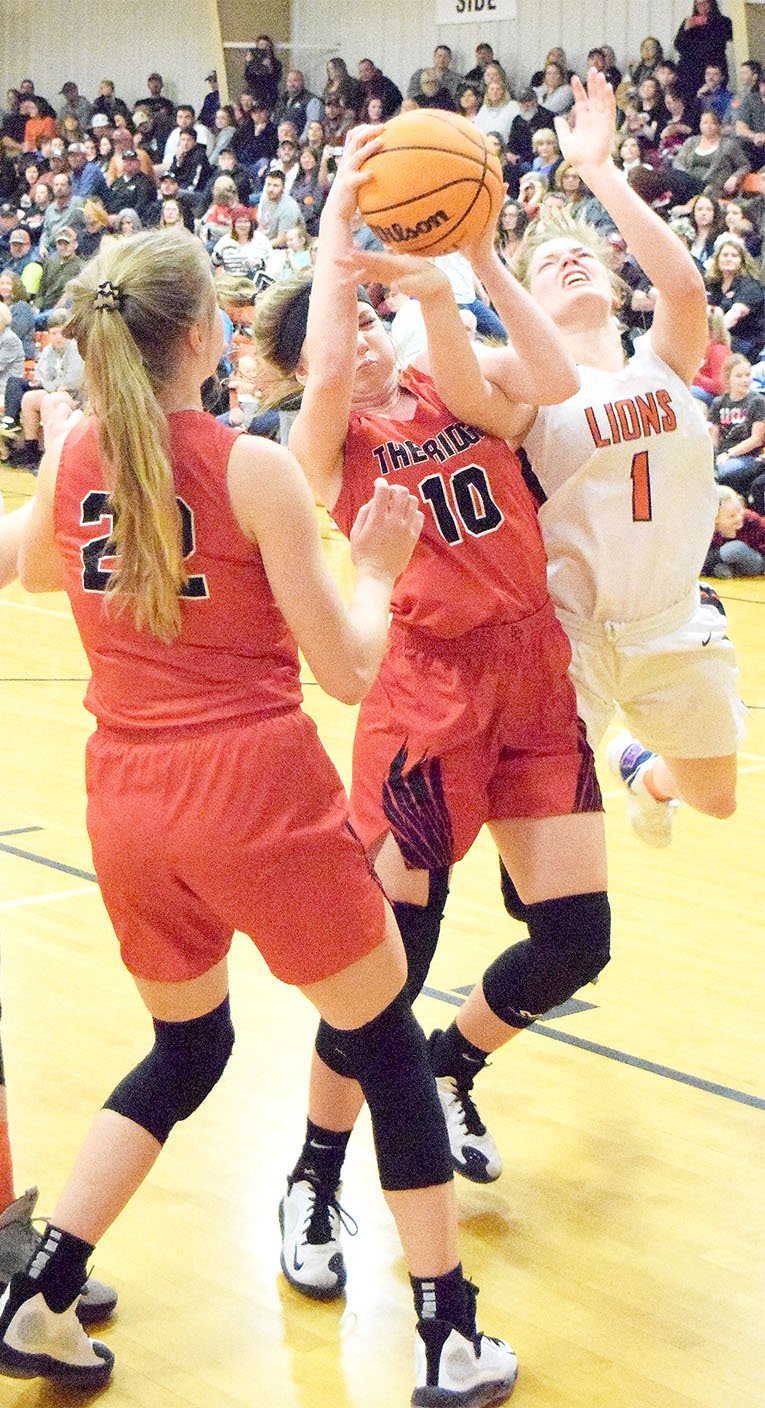 Staff photograph by Mike Eckels Junior Lady Blackhawks Ravin Cawthon (No. 10) and Blakelee Winn (No. 22) in the hard-fought contest Friday, Feb. 14, in Gravette against the Lady Lions. Winn led all scorers with 17 points; Cawthon scored 4 points.