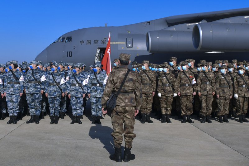 In this Monday, Feb. 17, 2020, photo released by Xinhua News Agency, military medics stand in formation as they arrive at Tianhe International Airport in Wuhan in central China's Hubei Province. China reported thousands new virus cases and more deaths in its update Tuesday on a disease outbreak that has caused milder illness in most people, an assessment that promoted guarded optimism from global health authorities. (Li He/Xinhua via AP)