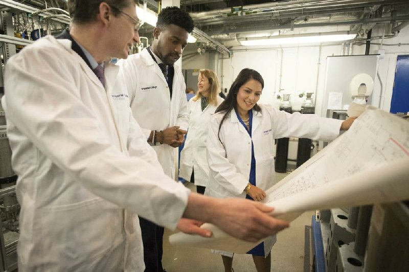 British Home Secretary Priti Patel meets Tuesday with students and staff members working on a “carbon capture” project at Imperial College in London. Patel said Wednesday that a post-Brexit immigration policy requiring migrants to meet special criteria for work visas is “a historic moment for the whole country.”
(AP/Stefan Rousseau)