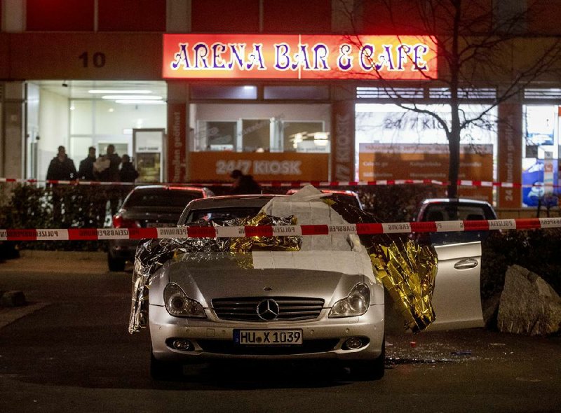 A car where victims were shot sits on the street early today in Hanau, Germany, as police investigate.
(AP/Michael Probst)