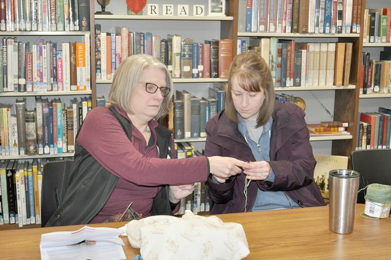 RACHEL DICKERSON/MCDONALD COUNTY PRESS Cindy Buchite (left) helps Julie Armer with her crochet project at the McDonald County Library yarn group on Tuesday, Feb. 4.