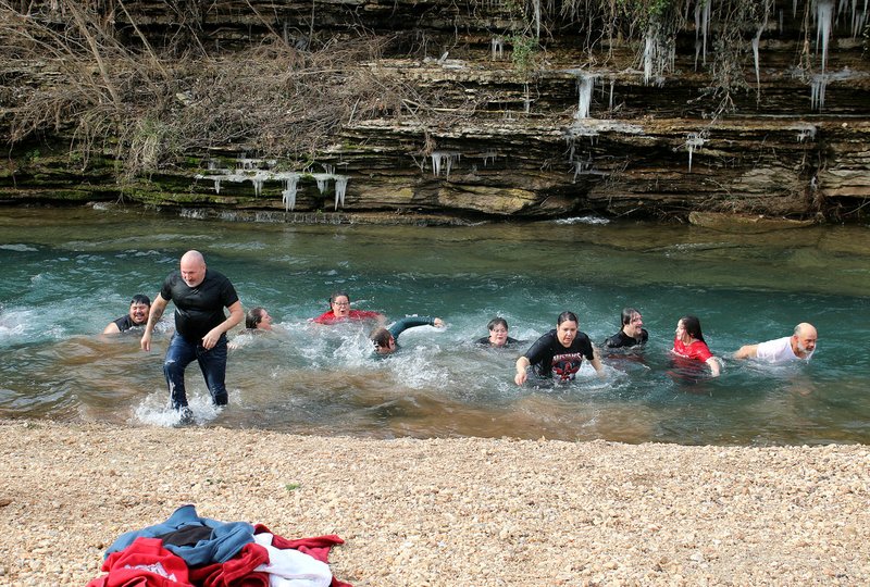 MEGAN DAVIS/MCDONALD COUNTY PRESS Freezing folks bolt to the shore of Indian Creek for a dry towel after participating in a Polar Plunge at Anderson's Town Hole on Saturday. The event was held in solidarity with youth in need who may be experiencing times of hunger or cold.