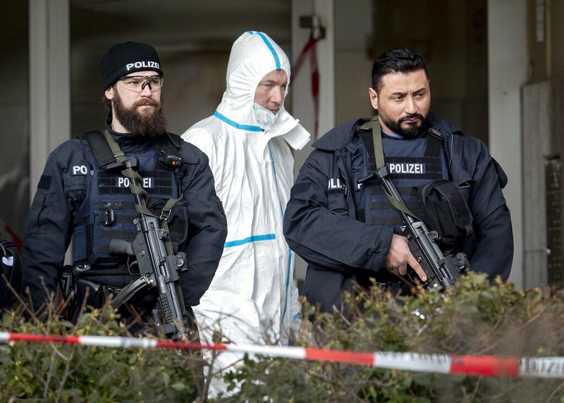 German police officers guard the entrance of a bar where several people were killed late Wednesday in Hanau, Germany, Thursday, Feb. 20, 2020. A 43-year-old German man shot and killed several people at more than one location in a Frankfurt suburb overnight in attacks that appear to have been motivated by far-right beliefs, officials said Thursday. (AP Photo/Michael Probst)