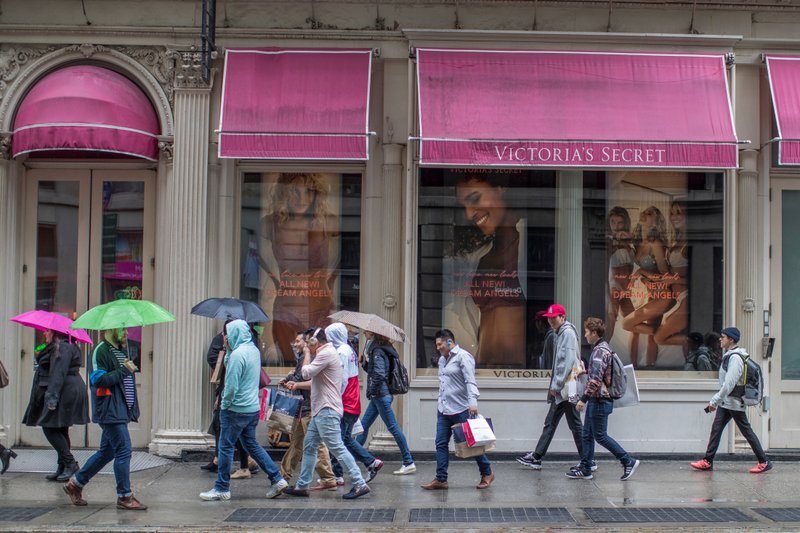 FILE- In this April 4, 2018, file photo, shoppers walk past the Victoria's Secret store on Broadway in the Soho neighborhood of New York. Victoria's Secret's owner, L Brands, said that the private-equity firm Sycamore Brands will buy 55% of Victoria's Secret for about $525 million. Victoria's Secret will become a private company. (AP Photo/Mary Altaffer, File)

