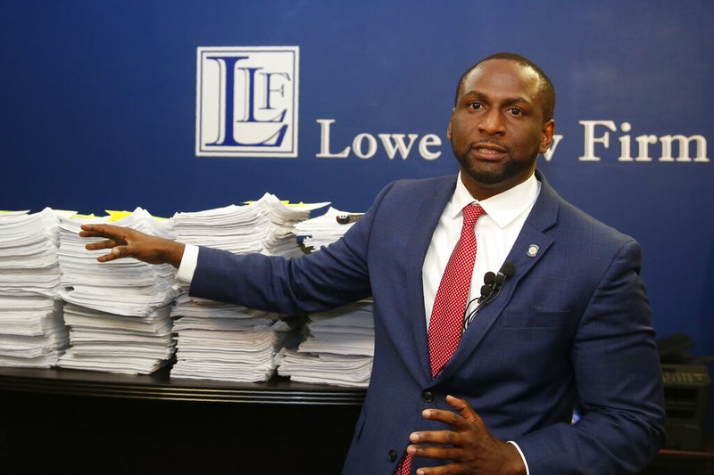 In this Aug. 29, 2019 file photo, Oklahoma state Rep. Jason Lowe, D-Oklahoma City, gestures to a stack of petitions to seek to suspend a new permitless carry law during a news conference in Oklahoma City. An Oklahoma House committee has overwhelmingly rejected a bill by Lowe to repeal a new law that allows most adults to carry firearms without a background check or training. Lowe promised to continue fighting the measure with an initiative petition seeking a public vote on whether to overturn the law that went into effect in November. (AP Photo/Sue Ogrocki, File)