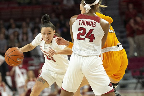 Arkansas guard Amber Ramirez drives around a Tennessee defender while teammate Taylah Thomas (24) sets a screen during a game Thursday, Feb. 20, 2020, in Fayetteville.
