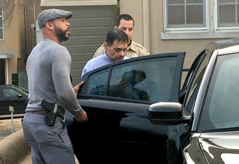 Mauricio Torres walks to a police vehicle Wednesday while being escorted outside the Benton County Courthouse in Bentonville. (NWA Democrat-Gazette/Tracy Neal)