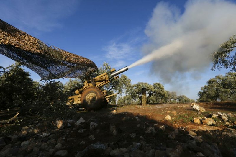 Turkish-backed rebel fighters fire a howitzer toward Syrian government forces Thursday near the village of Neirab in Idlib province, Syria.
(AP/Ghaith Alsayed)
