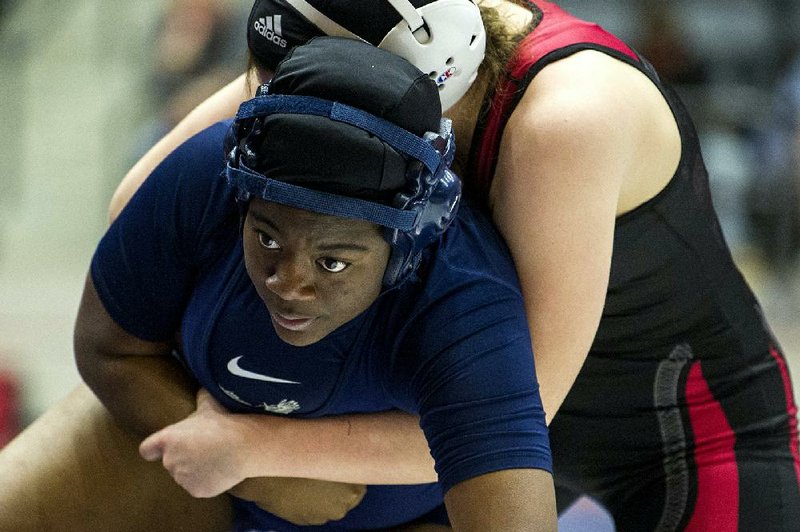 Little Rock Fair’s Crystal Allen tries to escape from Searcy’s Harley Seymore in the championship match of the 185-pound division Thursday. Allen pinned Seymore in 3:20 to win the state title. Allen’s Fair teammates Journey Land (165 pounds) and Victoria Harris-Dove (235 pounds) also claimed state championships in what will be the Lady War Eagles’ only appearance in the tournament. Students at Fair and Little Rock McClellan will attend the new Little Rock Southwest High School this fall.
(Arkansas Democrat-Gazette/Stephen Swofford)