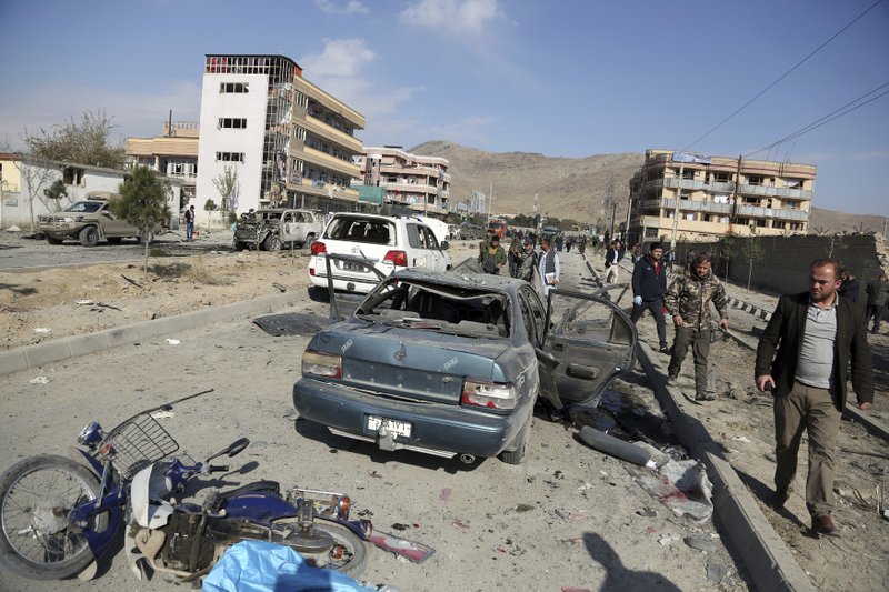 FILE- in this Wednesday, Nov. 13, 2019, file photo, Afghan security personnel gather at the site of a car bomb attack in Kabul, Afghanistan. Afghanistan will need vast amounts of foreign funding to keep its government afloat through 2024, a U.S. agency said Thursday, even as foreign donors are increasingly angry over the cost of debilitating corruption and the U.S. seeks a peace deal with Taliban to withdraw its troops. (AP Photo/Rahmat Gul, File)

