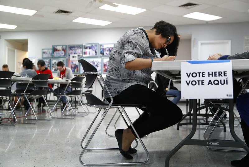 FILE - In this Feb. 15, 2020, file photo, a woman votes at an early voting location at the culinary workers union hall in Las Vegas. Nevada Democrats are hoping to avoid a repeat of the chaos that ensnared the Iowa caucuses, as voters gather across the Silver State on Saturday to make their presidential preferences known.

