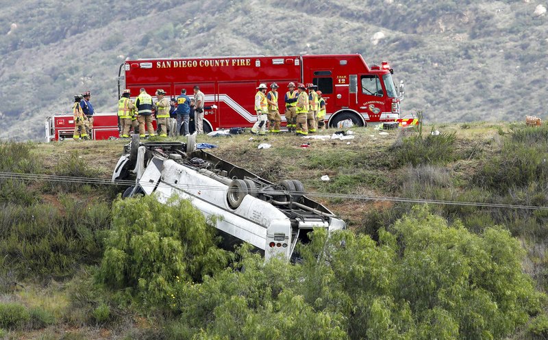 Firefighters and emergency workers respond to a charter bus that rolled over on Interstate 15, about 45 miles north of San Diego, on Saturday. The North County Fire Protection District said crews rescued several people trapped in the wreckage.