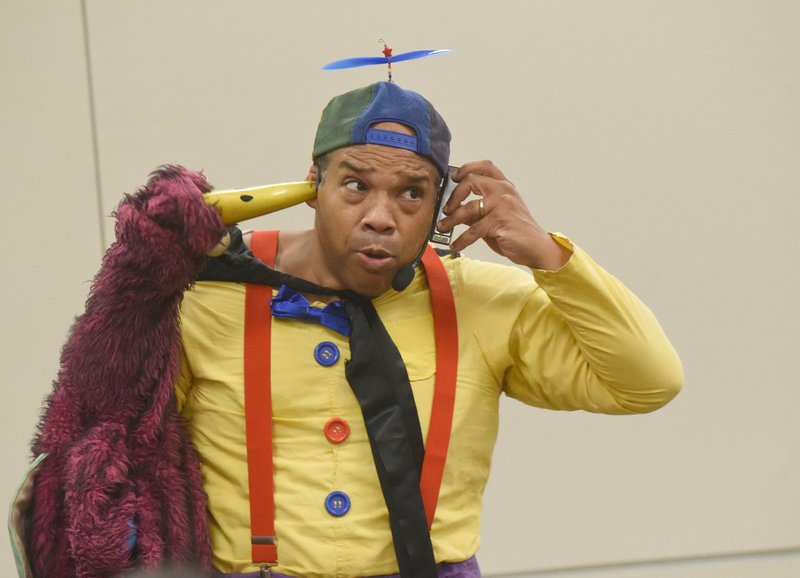 NWA Democrat-Gazette/FLIP PUTTHOFF 
MAGICIAN MUSICIAN
Tommy Terrific plays a harmonica through his ears Wednesday July 25 2018 during his &quot;Rockin' Magic&quot; comedy and magic show for children at the Rogers Public Library. The magician from Little Rock will be at the Bentonville Public Library today for shows at 10:30 a.m. and 2 p.m.