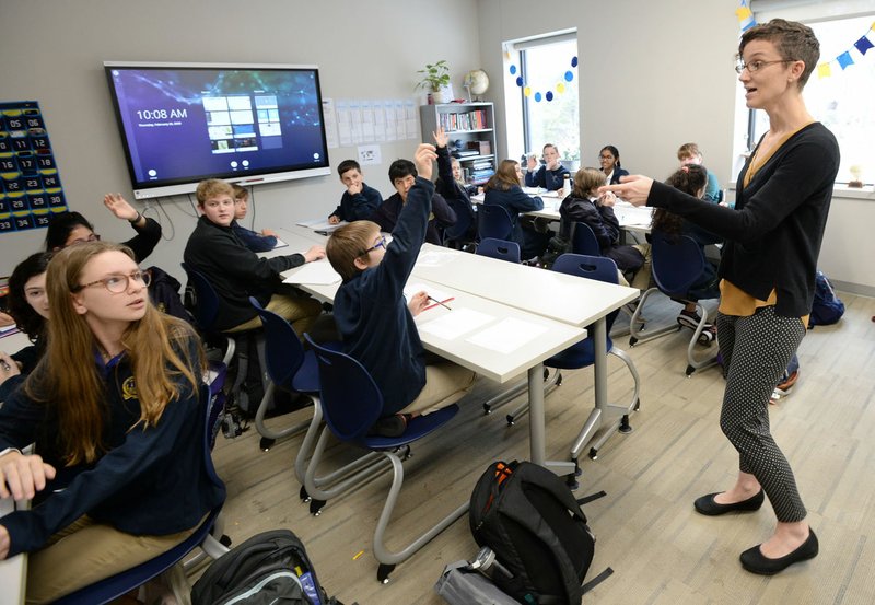 Sarah Kilgus (right) speaks Thursday to her seventh-grade class at Haas Hall Academy in Fayetteville. The state Department of Education last year agreed to work with the charter school to increase diversity among its faculty, staff and student body. Go to nwaonline.com/200222Daily/ for today's photo gallery. (NWA Democrat-Gazette/Andy Shupe)