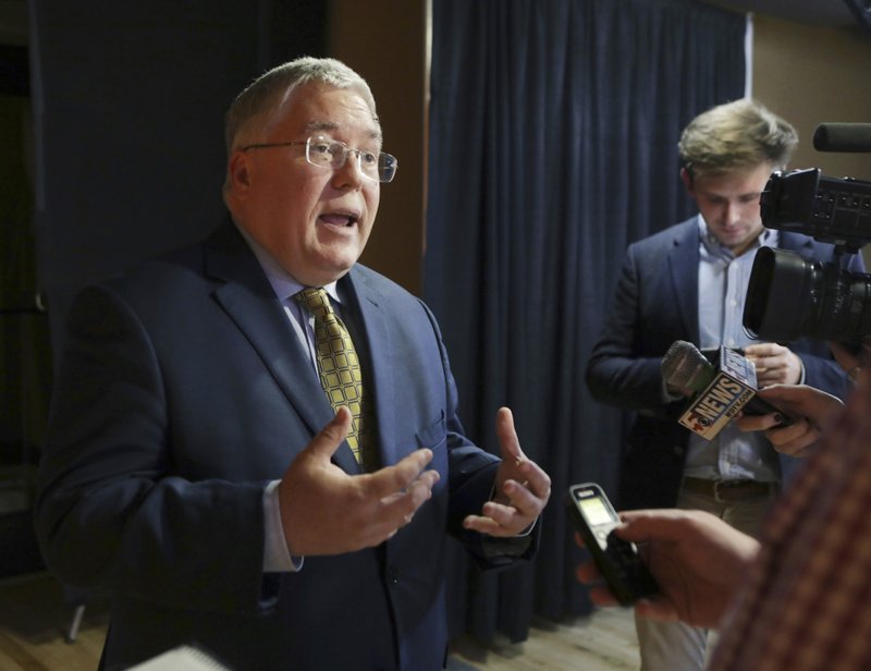 FILE - In this Nov. 1, 2018, file photo, Patrick Morrisey speaks to reporters after a debate in Morgantown, W.Va. State attorneys general are finding a national settlement over the toll of opioids to be elusive, as some lawyers for state and local governments are renewing public criticism of the proposed deal with a group of companies led by the nation's largest drug distributors. (AP Photo/Raymond Thompson, File)