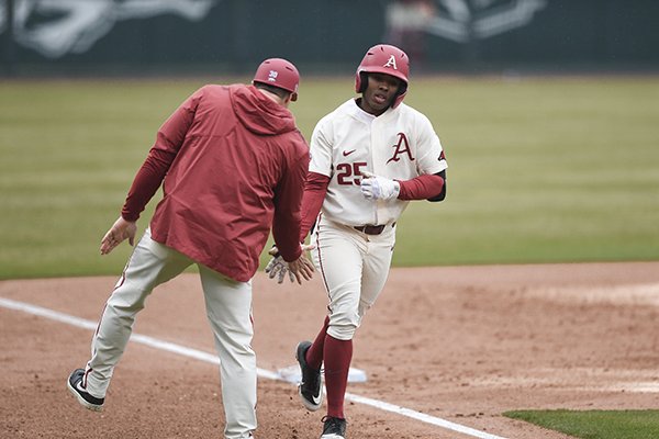 Arkansas center fielder Christian Franklin (25) is congratulated by assistant coach Nate Thompson after hitting a home run during a game against Gonzaga on Sunday, Feb. 23, 2020, in Fayetteville. 