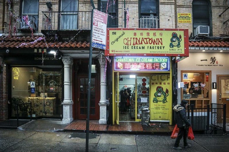 A woman earlier this month walks past Chinatown Ice Cream Factory, a neighborhood fixture owned by Christina Seid and founded by her father four decades ago in New York. (AP/Bebeto Matthews) 